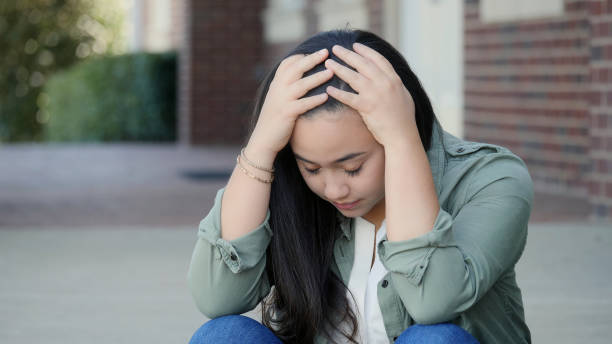 istock Young, overwhelmed female rests her hands in her head 1072675780