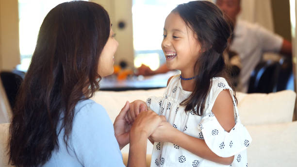 istock Young girl and her mother laugh while holding hands 1072677440