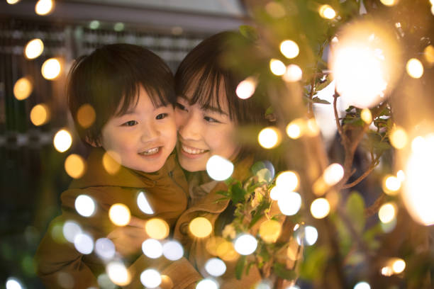 mutter und sohn genießen weihnachtsbeleuchtung - lichterkette dekoration fotos stock-fotos und bilder