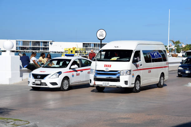 Taxi cars in motion San Miguel de Cozumel, Mexico - 9th January, 2018: Nissan Versa and Toyota Hiace in taxi version driving on the street. These models are a popular vehicles in taxi corporations in Mexico. san miguel de cozumel stock pictures, royalty-free photos & images