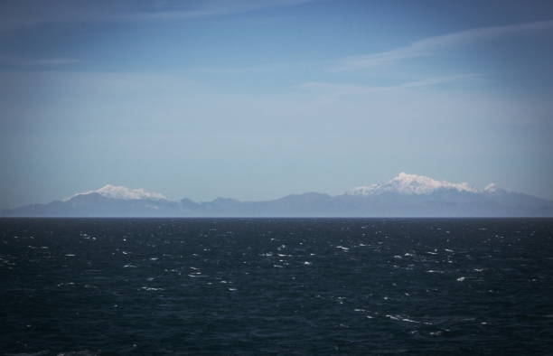 immagine di sfondo delle montagne innevate della nuova zelanda viste dallo stretto di cook. - cook strait foto e immagini stock