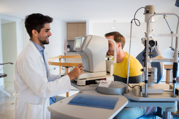 optometrist with patient - macular degeneration imagens e fotografias de stock