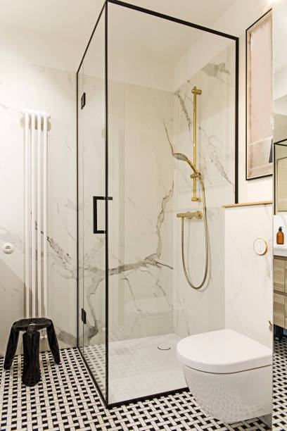 уютная и стильная ванная комната с белыми стенами и дизайнерскими аксессуарами. - bathroom shower glass contemporary стоковые фото и изоб�ражения