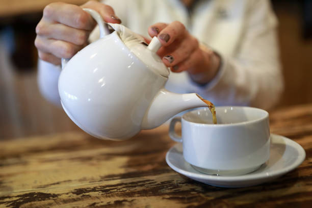 istock Person pouring black tea 1072758848