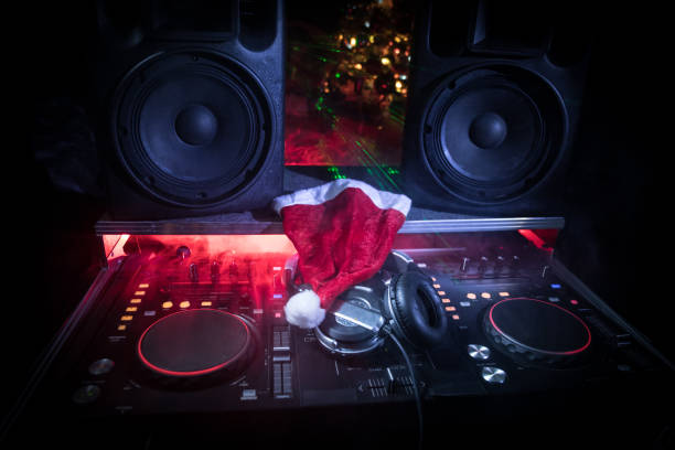 table de mixage dj avec un casque sur fond de boîte de nuit sombre avec arbre de noël nouvel an. bouchent la vue des éléments de la nouvelle année dans une table de dj. concept de vacances de parti. - christmas tree audio photos et images de collection