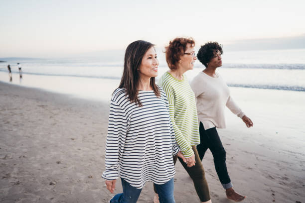 istock Seniors friends walking on the beach 1072792676