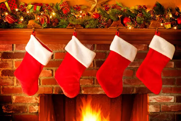 Photo of Stockings Hanging From Christmas Mantelpiece Above Roaring Fireplace