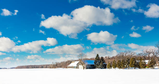 Antique barn in a snow covered winter landscape in Quebec, Canada.