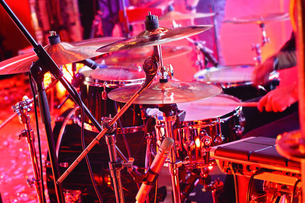 istock drummer playing on drum set on stage during the concert. Focus on the drum and microphone, blurred motion effects 1072806124
