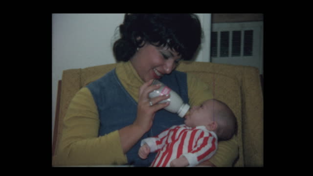 1971 Mom bottle feeds infant baby boy