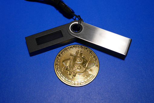 Vancouver, Canada, November 26, 2018: Bitcoin cryptocurrency coin - close up photo of one gold-plated bitcoin symbolizing the market, modern technology, finance, internet, trading, etc.
