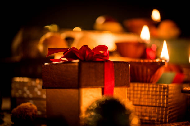 Diwali diya or lighting in the night with gifts, flowers over moody background. Selective focus Diwali diya or lighting in the night with gifts, flowers over moody background. Selective focus diwali photos stock pictures, royalty-free photos & images