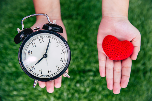 giving love times heart and clock on girl hand.