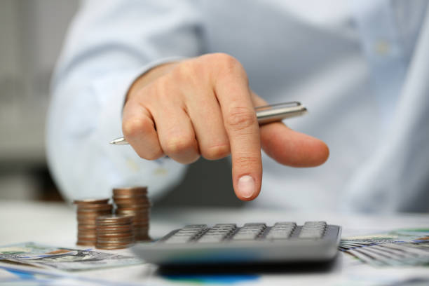 istock Male hand push key silver calculator is lying 1072865584
