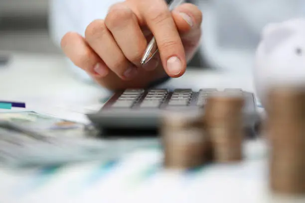 Photo of Male hand push key silver calculator is lying