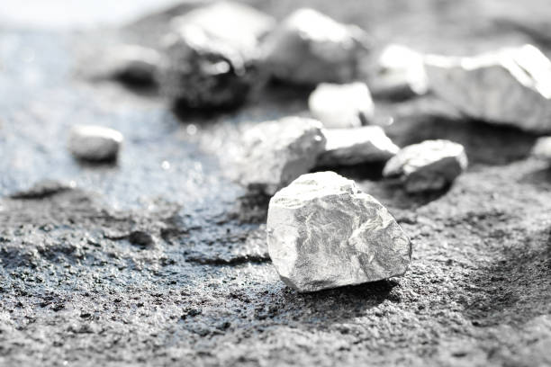 lump of silver or platinum on a stone floor lump of silver or platinum on a stone floor metal ore stock pictures, royalty-free photos & images