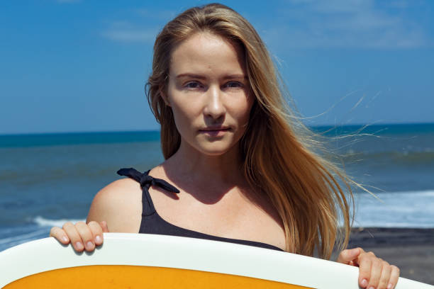 istock Surfer girl on tropical beach 1072925440
