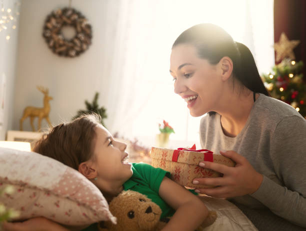 istock mom preparing Cristmas gift to daughter 1072932754