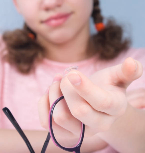 sonrisa, primer plano, mano sostiene gafas, y hay una lente en un dedo para mejorar la visión - human eye eyesight optometrist lens fotografías e imágenes de stock