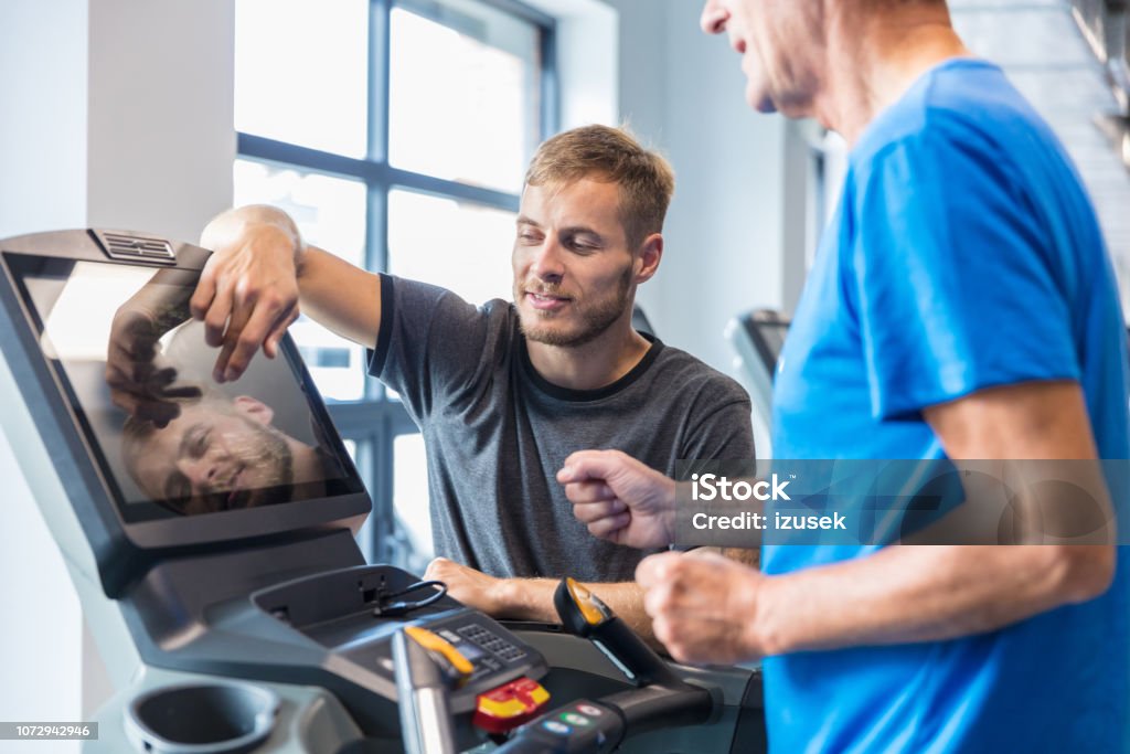 Tränare som övervakar gubbe på löpband - Royaltyfri Hjärta Bildbanksbilder