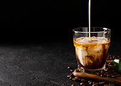 glass cold brew coffee with ice and milk on black or dark background