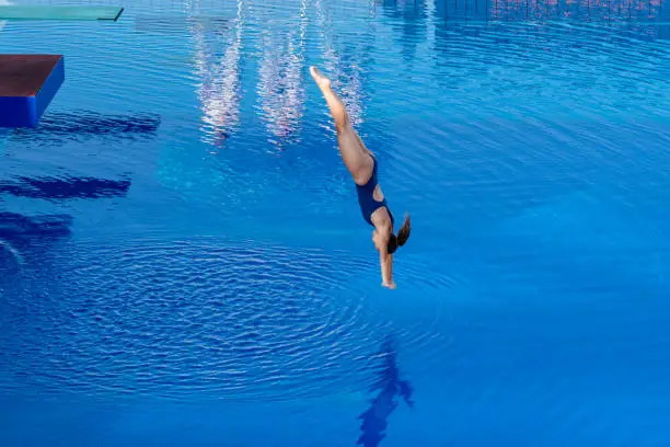 Photo of Young woman diving in swimming pool