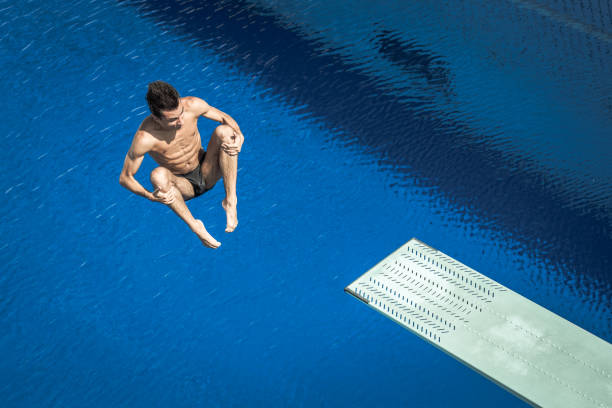 young man diving in swimming pool - shirtless energy action effort imagens e fotografias de stock