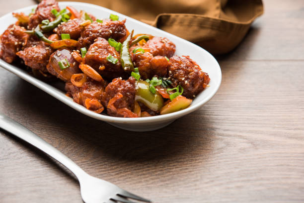 istock Indian Chilli Chicken dry, served in a plate over moody background. Selective focus 1072950586