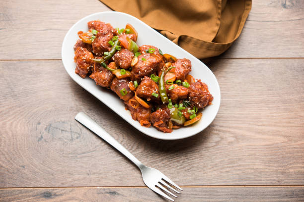 istock Indian Chilli Chicken dry, served in a plate over moody background. Selective focus 1072950650