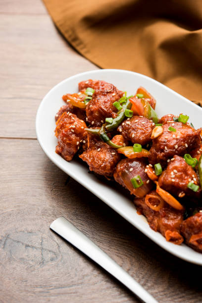 istock Indian Chilli Chicken dry, served in a plate over moody background. Selective focus 1072950988