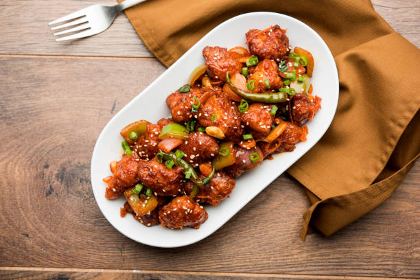 Indian Chilli Chicken dry, served in a plate over moody background. Selective focus
