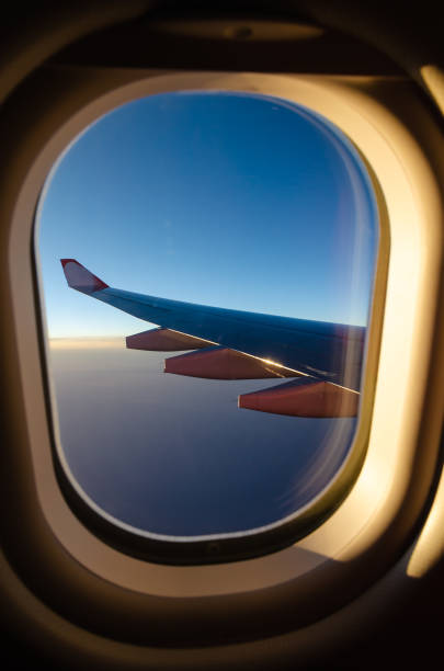 istock Outside the window's airplan sunset seen with aircraft wing. 1072951294