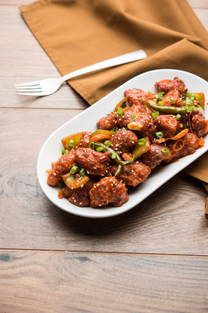istock Indian Chilli Chicken dry, served in a plate over moody background. Selective focus 1072951318