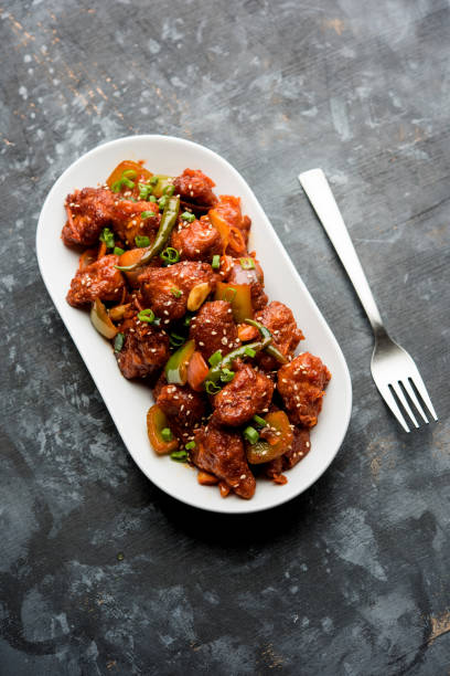 istock Indian Chilli Chicken dry, served in a plate over moody background. Selective focus 1072951400