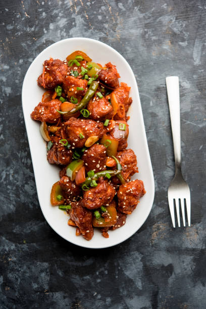 istock Indian Chilli Chicken dry, served in a plate over moody background. Selective focus 1072951524