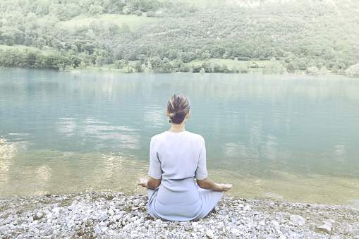 woman doing yoga in front of a spectacular mountain lake