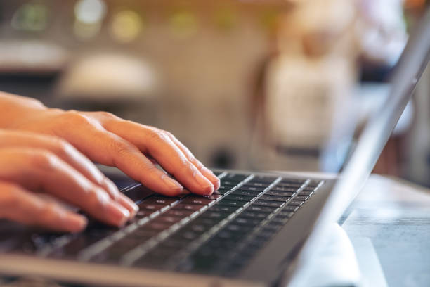 istock Closeup image of hands using and typing on laptop keyboard in cafe 1072953564