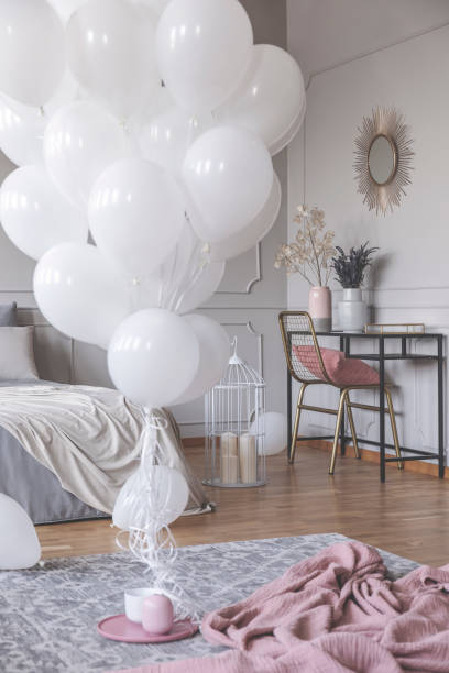 istock White balloons and blanket on a floor in a bedroom interior 1072953648