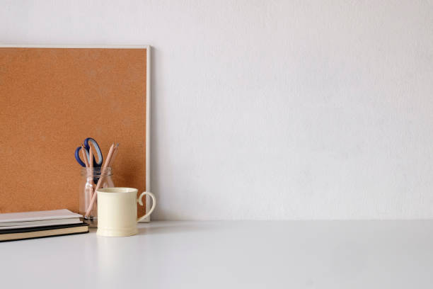 istock Coffee mug, notebook, pencil and office supplies with copy space on white table. 1072960880