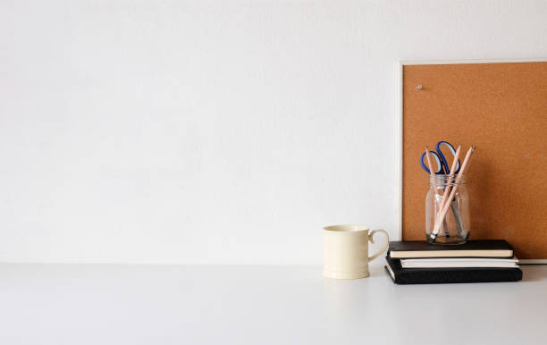 istock Coffee mug, notebook, pencil and office supplies with copy space on white table. 1072960924