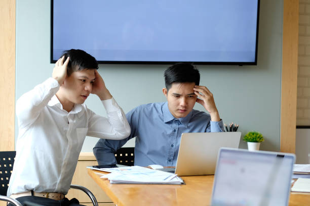 istock Stressed two businessman with laptop computer and documents at office. 1072963446