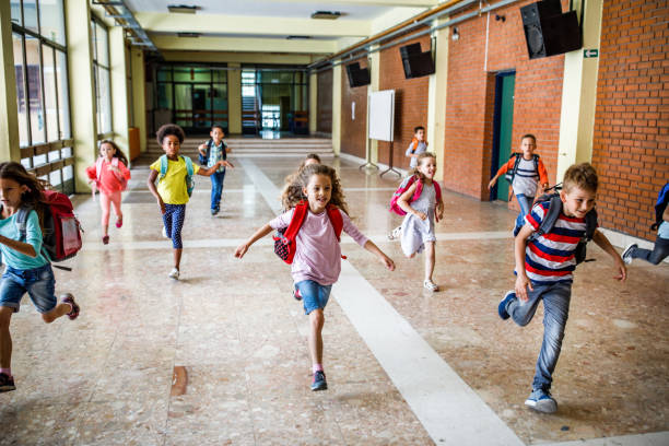 istock Large group of elementary students running in the school hallway. 1072966130