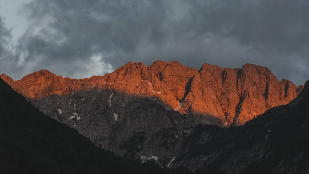 Alpenglow sunset over the Triglav mountains from the Soča valley stock photo