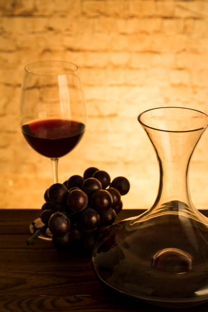 istock Red Wine in Decanter and Glass. And grapes on table 1072971008