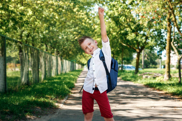 istock Back to school. A boy from an elementary school with a backpack on the street. The concept of the day of knowledge, September 1, the beginning of school. 1072980532