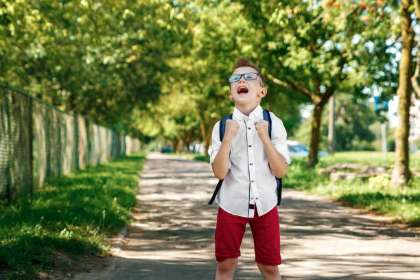 istock Back to school. A boy from an elementary school with a backpack on the street. The concept of the day of knowledge, September 1, the beginning of school. 1072980598