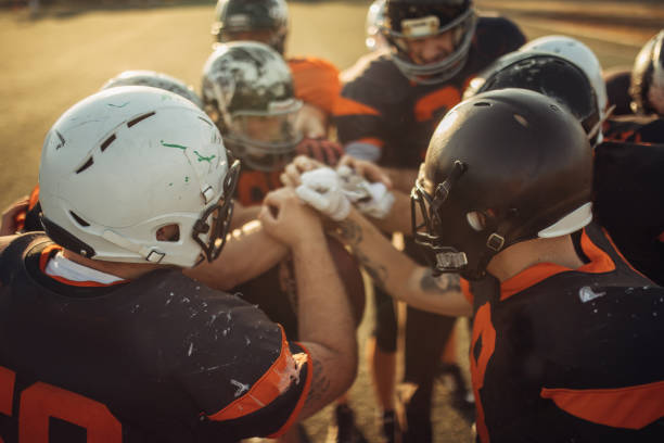 istock Football team holding hands 1072984132