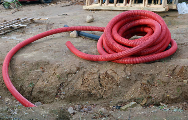 istock Red armed plastic pipes for a drainage and melioration lie on a city construction site 1072984432