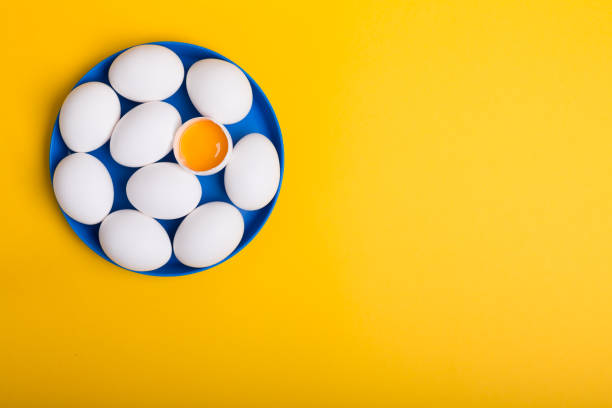 istock White eggs and egg yolk on the yellow background 1072994724