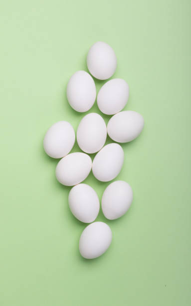 istock White eggs and eggs on the green background 1072994872